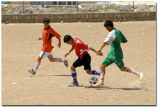 Three boys playing football